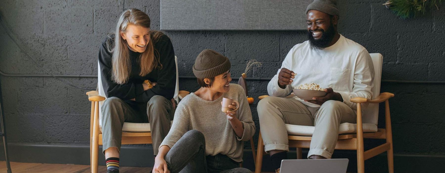 friends sit together around an open laptop